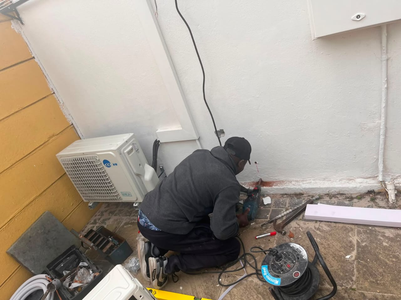 Mike Cooling Solutions technician fitting an outdoor condenser unit on site